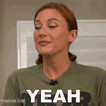 a woman wearing a green shirt with the word yeah on it