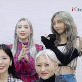 a group of young women are standing next to each other and smiling for the camera .