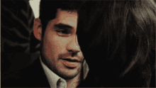 a man and woman are hugging and the woman is covering her face with her hair