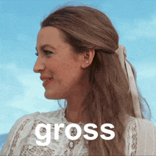 a woman wearing a white lace top with the word gross on the bottom