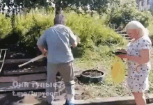 a man and a woman are standing next to each other in a park