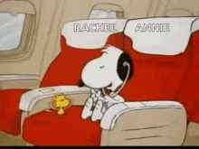 snoopy and woodstock are sitting on a plane with headphones on .