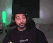 a man wearing headphones and a beard is giving a high five to another man .