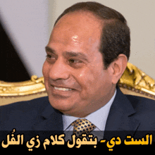 a man in a suit and tie is smiling in front of a sign in arabic