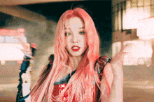 a woman with pink hair is wearing a red dress