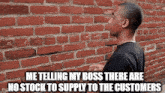 a man is standing in front of a brick wall and talking to his boss about no stock to supply to the customers .