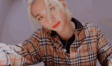 a close up of a person wearing a plaid shirt .