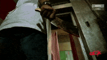 a man is holding a bloody knife in front of a door that says astro on it