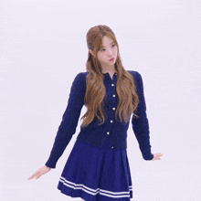 a woman wearing a blue sweater and a blue skirt