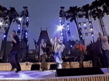 a group of people are dancing on a stage in front of a crowd .