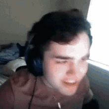 a man wearing headphones is sitting in front of a computer screen .