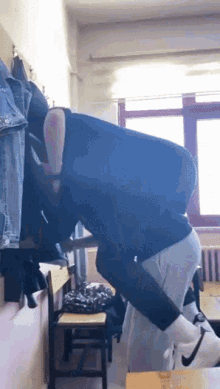 a man in a black shirt is kneeling down in a classroom