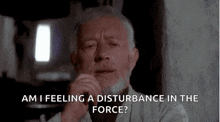 an older man with a beard is sitting in a dark room and talking about a disturbance in the force
