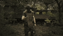 a soldier wearing a helmet and a mask is holding a sniper rifle in a field .