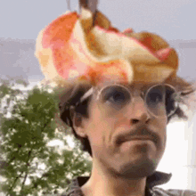 a man wearing a hat with a hot dog on it