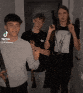 three young men holding guns in front of a door and a sign that says tik tok