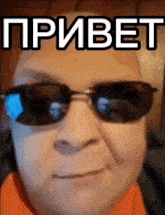 a man wearing sunglasses has the word " привет " on his face