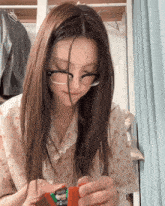 a girl wearing glasses is holding a toy in her hands