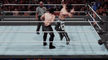 two wrestlers in a wrestling ring with a referee