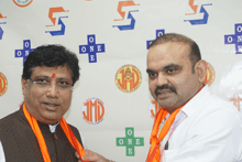 two men are standing in front of a wall that says jmd