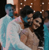 a man and a woman are hugging and smiling at each other