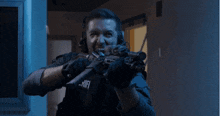 a man is holding a gun with a rift logo on his chest