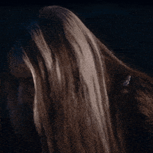 a woman with long brown hair is looking down