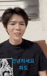 a young man wearing a black t-shirt with chinese writing on the front
