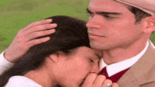 a man kisses a woman on the forehead while wearing a ring on his finger