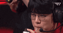 a man wearing a headset and glasses drinking through a straw