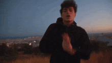 a blurry picture of a man in a black jacket standing in a field