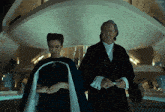 a man and a woman are standing in front of a building that says kepler on it