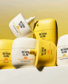 several bottles of avon beyond glow sunscreen are stacked on top of each other