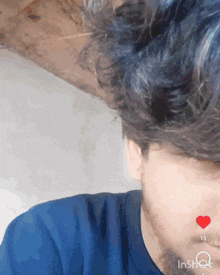 a close up of a man 's face with a red heart on his nose