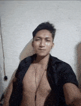 a shirtless man is wearing headphones and a black shirt