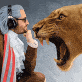 a man wearing a wig and headphones looks at a lion with its mouth open
