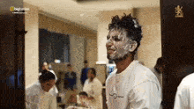 a man with foam on his face is standing in front of a mirror with the bigbasket logo on the bottom right