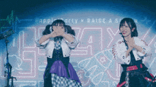 two girls are performing in front of a sign that says poppin party