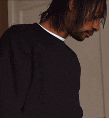 a man in a black shirt is looking down at something