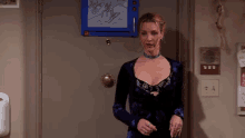 a woman in a purple dress is standing in front of a door .
