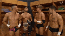 a group of wrestlers are standing in a locker room with the word n on the bottom left