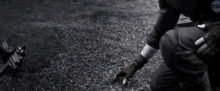 a black and white photo of a man kneeling on the ground with the word film in the corner
