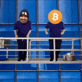 two men are standing on a balcony with one wearing a hat that says la