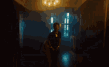 a man in a black shirt is walking through a dark room