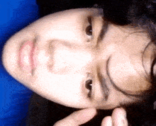 a close up of a person 's face with a blue shirt