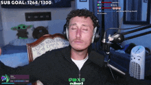 a man sitting in front of a microphone with a sub goal of 1264 1300