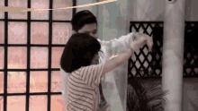 a man and a woman are dancing in front of a fence with the number 89 on it
