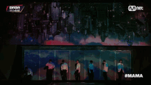 a group of people standing in front of a screen that says mama on it