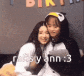 two girls in penguin costumes are hugging each other with the words rafis y ann : 3 below them .