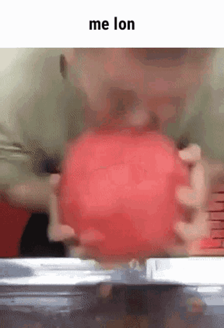 a person is holding a watermelon in their hands and the words me lon are above them .